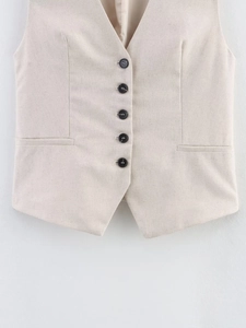 Detail of light beige vest featuring five buttons and textured fabric with pockets