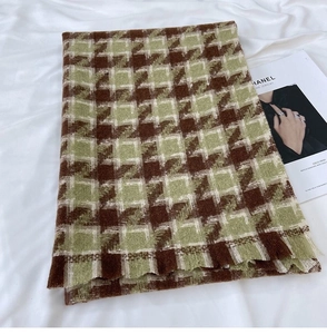 Detailed texture of thick houndstooth scarf with tassels in brown and green weave