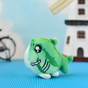 Detailed macro shot of a funny green shark plush keychain toy with watermelon print
