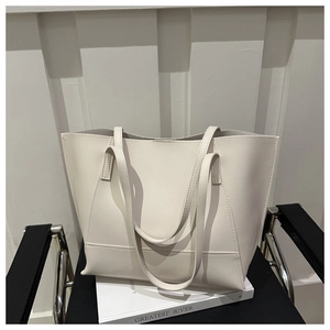 Borsa tote minimalista in pelle PU bianca su una poltrona nera con ambiente moderno