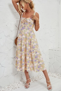 Detail of floral spaghetti strap dress with side slit and tied bust on a sunny day