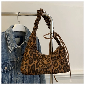 Détail du sac hobo léopard avec bandoulière plissée et cordons de serrage sur les côtés