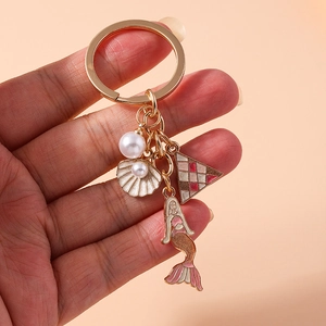 Detail of golden mermaid keychain with shell charms, star moon accents and faux pearls