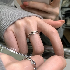 Minimalist silver chain link ring with a horseshoe cut design on a female finger