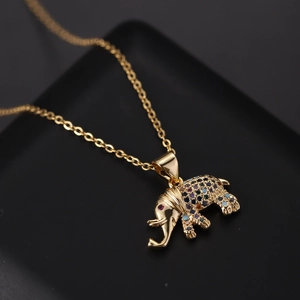 Close-up of golden elephant pendant necklace with colorful cubic zirconia on black base
