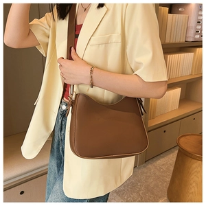 Brown PU leather shoulder bag worn by model in a stylish minimalist setting