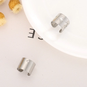 Detailed close-up of silver hollow star ear cuffs and polished metal ear clip set