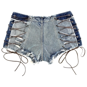 Dettaglio degli shorts di jeans blu con lacci laterali e design strappato effetto usurato