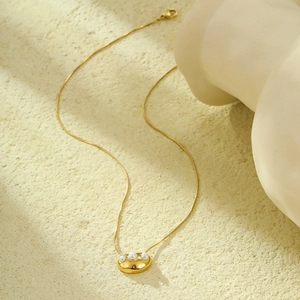 Minimalist gold snake chain necklace with three pearls in an oval geometric pendant