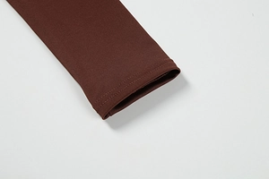 Macro shot of sleeve cuff detail on elegant slim-fit deep burgundy knitted dress