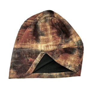 Detail view of double-sided knit beanie featuring tie-dye pattern and soft black lining