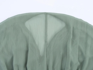 Nahaufnahme von salbeigrünem Chiffonstoff mit eleganter vertikaler Faltenstruktur und Details