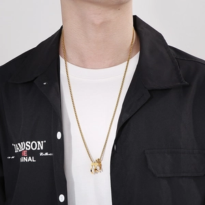Close-up of a multi-layer gold pendant with zircon stones on a twist chain necklace
