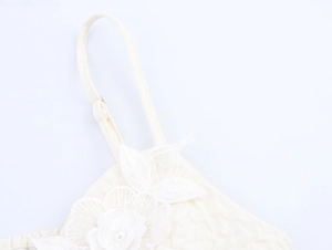Détail de la caraco en dentelle blanche avec broderies florales 3D et perles
