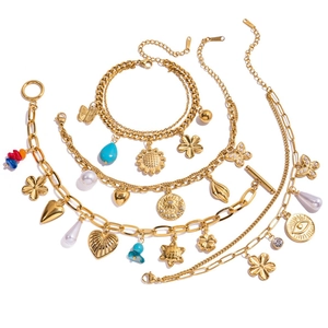 Détail de bracelets à breloques dorés 18K avec perles et pendentifs papillon