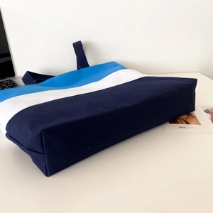 Detail shot of the tricolor canvas tote bag bottom and side in blue and white