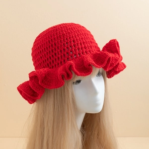 Detail of red crochet knit fisherman hat with ruffled brim on a white mannequin head
