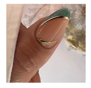 Macro detail of emerald green and pink almond press-on nails with gold lines and rhinestones