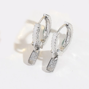 Macro detail of silver zipper-shaped earrings with sparkling cubic zirconia pavé setting