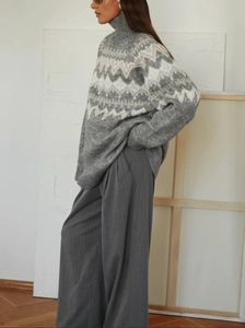 Detailed knit texture of Fair Isle sweater with retro geometric patterns and grey wide trousers