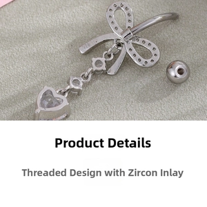 Detailed macro view showing the threaded design and inlaid zircon heart of the belly ring