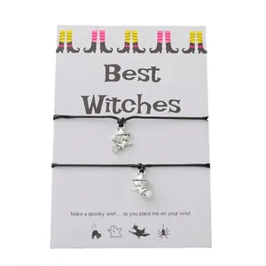 Detail of two black woven Halloween bracelets with silver witch on broomstick charms