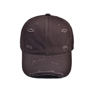 Close-up of distressed vintage cotton baseball cap with worn edges and frayed details