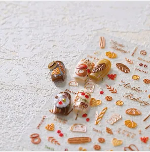 Détail macro de stickers ongles 3D pâtisserie avec motifs croissants et bretzels