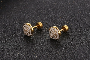Macro shot of gold-plated rose earrings with white enamel and secure screw-back closure