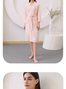 Detail of pink waffle texture bathrobe with classic V-neck, white trim, and matching belt