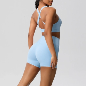 Detail of light blue sports bra with cross-back design and high-waist fitness shorts