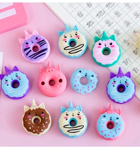 Close-up of colorful unicorn and animal-themed donut erasers on a pink background