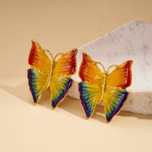 Macro detail of enamel butterfly stud earrings with vibrant multi-color gradient finish
