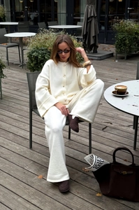 Close-up of the off-white knit cardigan and wide-leg pants set with refined texture