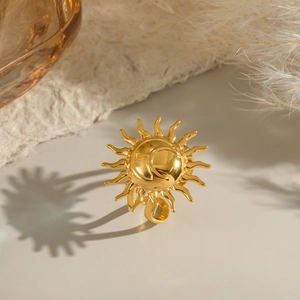 Golden stainless steel sun and moon ring set against an elegant minimalist background