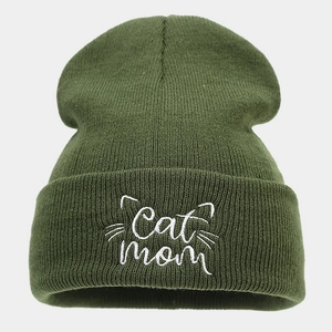 Close-up of white Cat mom embroidery and cat face pattern on green knit beanie hat