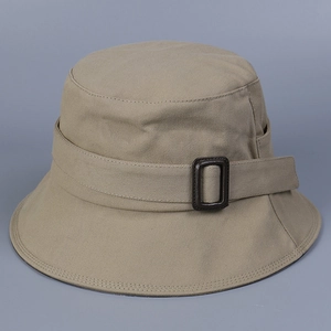 Close-up of khaki canvas bucket hat detailing fabric texture and dark brown buckle strap