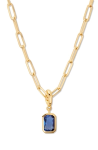 Detailed close-up of blue rectangular gemstone pendant on gold paperclip chain necklace