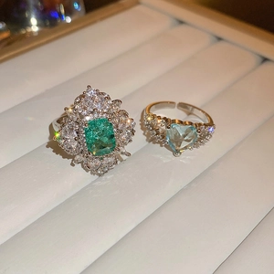 Macro detail of luxury double-layer rings with heart-shaped blue and green zircon stones