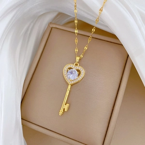 Detailed view of a gold heart key pendant necklace with sparkling zircons in a jewelry box