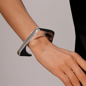 Detail shot of a silver irregular geometric triangle cuff bracelet on a model's wrist