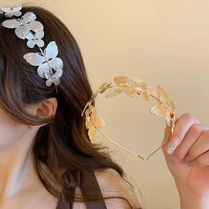 Close-up of golden and silver metal butterfly headbands with delicate matte textures