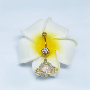 Dettaglio del piercing all'ombelico dorato con pietra rosa su un fiore bianco puro