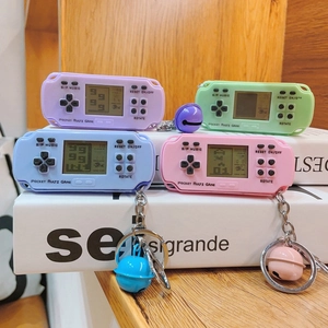 Close-up of retro mini game console keychains in pink, blue, purple, and mint green