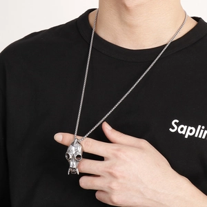 Retro punk style stainless steel skull pendant necklace worn by a male model