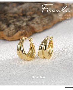 Macro detail of triple-layered gold-plated chunky hoop earrings with high-polish finish