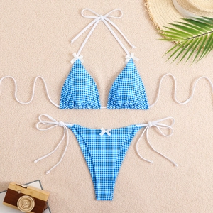 Flat lay of blue gingham bikini set with bow details and beach vacation accessories