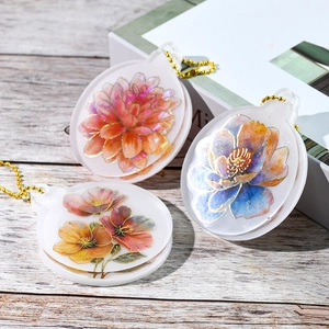 Detailansicht von Blumen-Acrylanhängern mit Goldrand und metallischen Kugelkettchen