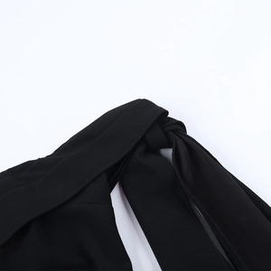 Détail de la robe noire avec nœud torsadé et texture de tissu à grain fin