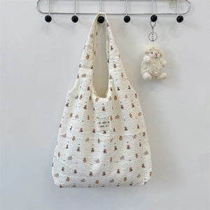 Detail of bear pattern on seersucker tote bag with cute sheep plush pendant